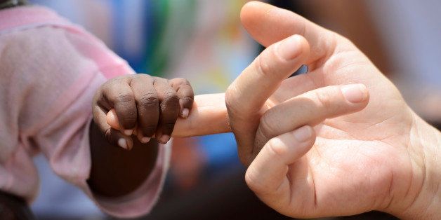 African Peace Symbol. White woman holds hands with a little baby native African girl, in Bamako, Mali. A black child and a white woman hold hands. Peace on earth symbol. Took this pic during my stay in Bamako, Mali in September 2015. A beautiful shot with lots of possible background symbols. No to Racism!