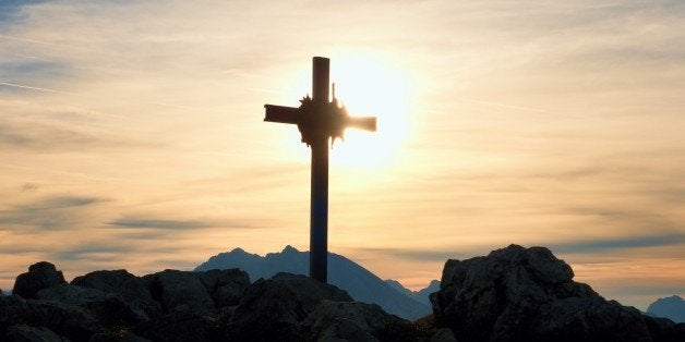 Iron cross at mountain top in alp. Cross on top of a mountains peak as typical in the Alps. Monument to the dead climbers