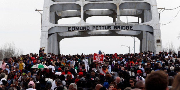 SELMA, AL - MARCH 8: Marchers retrace the steps of those who marched with Dr. Martin Luther King, Jr. 50 years ago over the Edmund Pettus Bridge in Selma, AL. (Photo by Jessica Rinaldi/The Boston Globe via Getty Images)