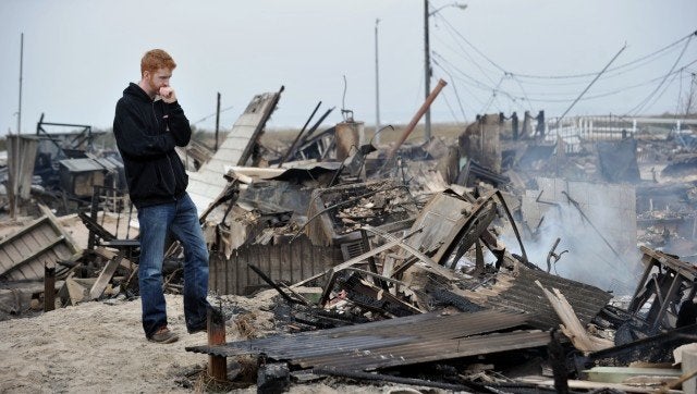 Gavin Byrne views damage in the Breezy Point area of Queens in New York on October 30, 2012 after fire destroyed about 80 homes as a result of Hurricane Sandy which hit the area on October 29. The death toll from superstorm Sandy has risen to 35 in the United States and Canada, and was expected to climb further as several people remained missing, officials said. Officials in the states of Connecticut, Maryland, New York, New Jersey, North Carolina, Pennsylvania, Virginia and West Virginia all reported deaths from the massive storm system, while Toronto police said a Canadian woman was killed by flying debris. AFP PHOTO/Stan HONDA (Photo credit should read STAN HONDA/AFP/Getty Images)