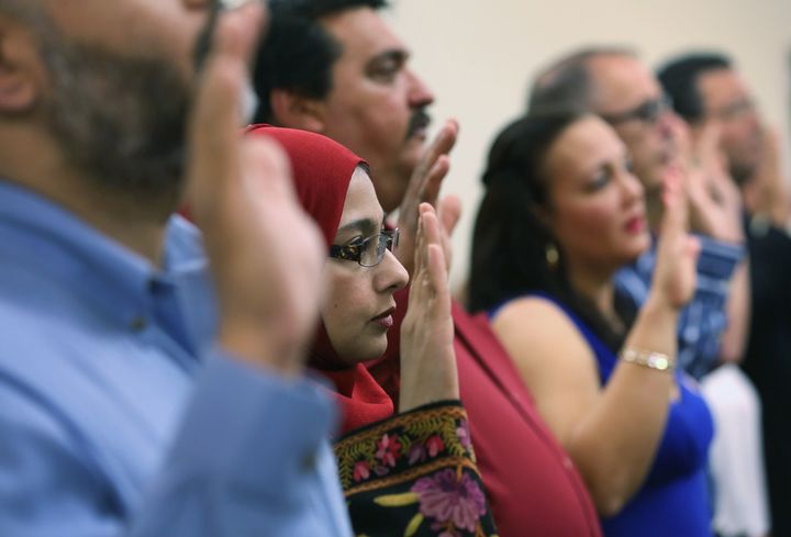 TAMPA, FL - FEBRUARY 14: Indian immigrant Arshi Khan takes the oath of citizenship while becoming American citizens at a special Valentines Day naturalization ceremony for married couples on February 14, 2013 in Tampa, Florida. The U.S. Citizenship and Immigration Service (USCIS) held the Valentine''s Day ceremony in their Tampa office for 28 married couples from 15 different countries. (Photo by John Moore/Getty Images)