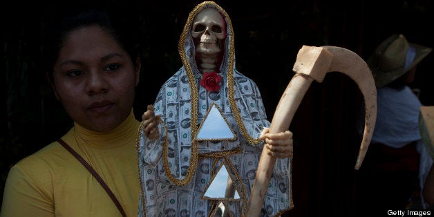 OAXACA, MEXICO - NOVEMBER 2: A woman carries a skeletal figure representing the folk saint known in Mexico as 'Santa Muerte'