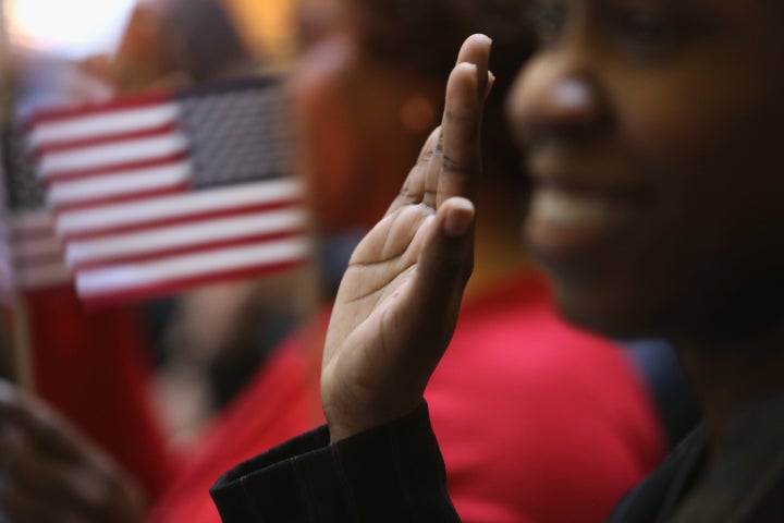 NEW YORK, NY - MARCH 22: Immigrants raise their hands for the oath of allegiance to the United States to become American citizens at Federal Hall on March 22, 2013 in New York City. Seventy-four immigrants from 39 different countries took part in naturalization ceremony held in the historic building where George Washington took the oath of office as the first President of the United States. (Photo by John Moore/Getty Images)