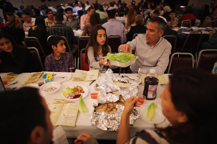 MIAMI BEACH, FL - MARCH 25: Omri Brandes, Nitzan Brandes and Bentsi Brandes (L-R) eat during a community Passover Seder at