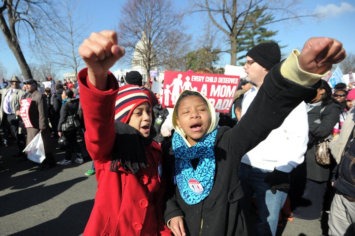 Two young girls shout slogans as they join anti same-sex marriage supporters in front of the US Supreme Court on March 26, 2013 in Washington, DC. The US Supreme Court on Tuesday takes up the emotionally charged issue of gay marriage as it considers arguments that it should make history and extend equal rights to same-sex couples. Waving US and rainbow flags, hundreds of gay marriage supporters braved the cold to rally outside the court along with a smaller group of opponents, some pushing strollers. Some slept outside in hopes of witnessing the historic hearing. AFP PHOTO/Jewel Samad (Photo credit should read JEWEL SAMAD/AFP/Getty Images)