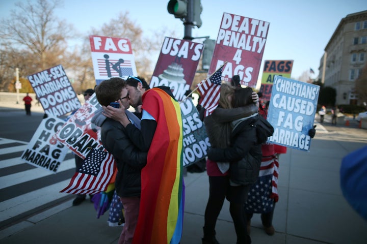 WASHINGTON, DC - MARCH 27: Two same sex couples kiss in front of Westboro Baptist Church protesters, at the U.S. Supreme Court, on March 27, 2013 in Washington, DC. Today the high court is scheduled to hear arguments on whether Congress can withhold federal benefits from legally wed gay couples by defining marriage as only between a man and a woman. (Photo by Mark Wilson/Getty Images)