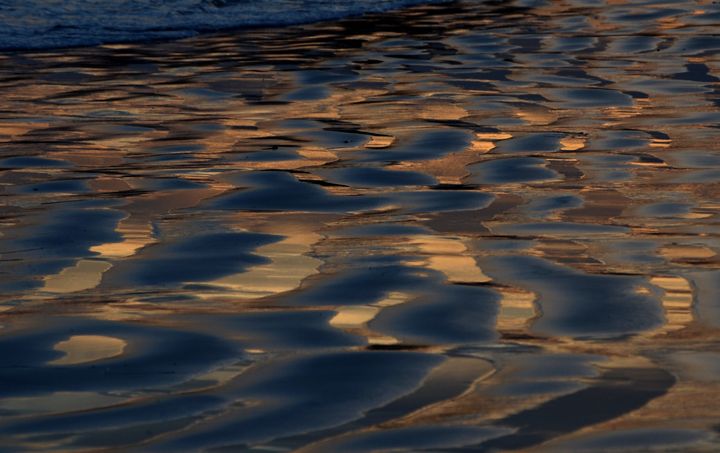 Sky reflects on sand after sunset at Leo Carrillo state beach north of Malibu, California on March 02,2013. In the last couple of days Southern Californians were enjoing summer temperatures and plenty of sunshine. AFP PHOTO/JOE KLAMAR (Photo credit should read JOE KLAMAR/AFP/Getty Images)