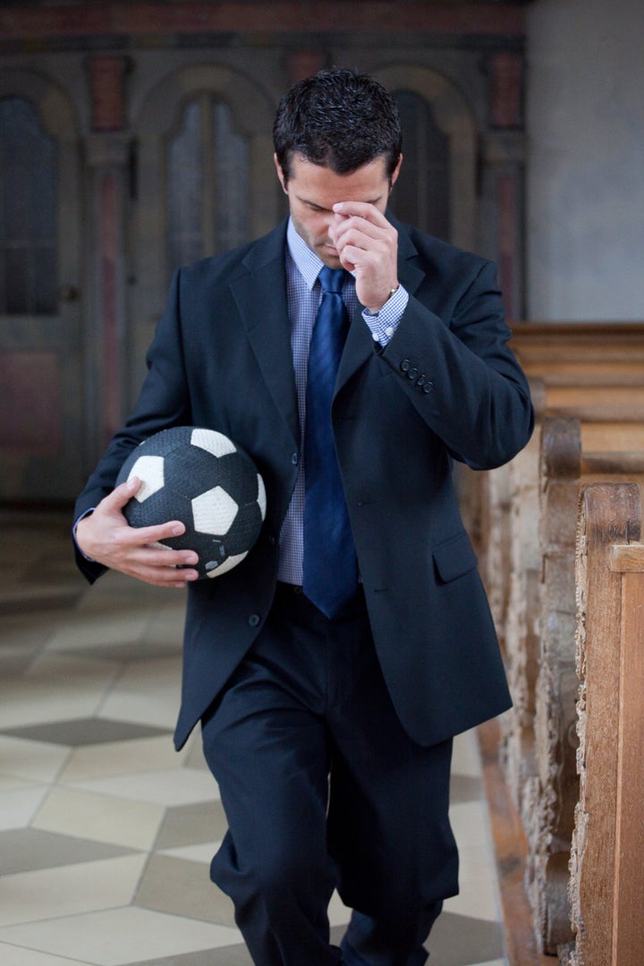 Man with football in prayer