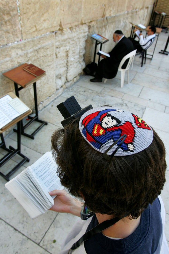 JERUSALEM - JUNE 15: A religious Jew wears a yarmulka, a Jewish skullcap, with a Superman design as he prays at the Western Wall June 15, 2005 in Jerusalem's Old City. The Western Wall is the last remnant of the Jewish Second Temple, which was destroyed by the Romans in 70 AD. (Photo by David Silverman/Getty Images)