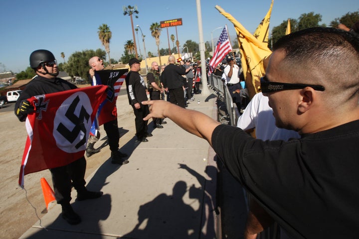 RIVERSIDE, CA - OCTOBER 24: Members of the white supremacist group, the National Socialist Movement and counter-protesters face off during the NSM's anti-illegal immigration rally near a Home Depot store on October 24, 2009 in Riverside, California. It is the second such demonstration in Riverside by the Detroit-based Neo-Nazi group in the past month. The last rally was broken up by police after clashes with counter-protesters. (Photo by David McNew/Getty Images)