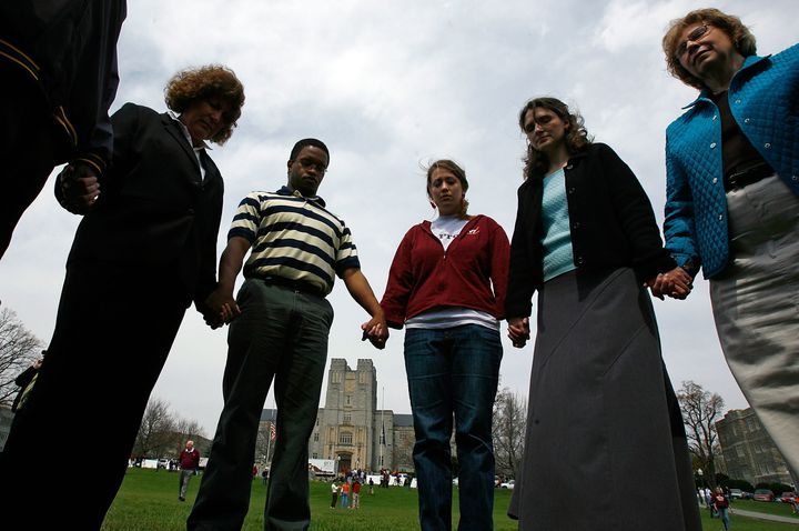 BLACKSBURG, VA - APRIL 18: Virginia Tech students, faculty and alumni pray during an interfaith service sponsored by the Virginia Tech Campus Ministry Association on the drill field of the university's campus April 18, 2007 in Blacksburg, Virginia. The university's community continues to mourn the victims of the rampage two days after more than 30 people were killed when a gunman opened fire on the campus in the deadliest school shooting in American history. (Photo by Win McNamee/Getty Images)