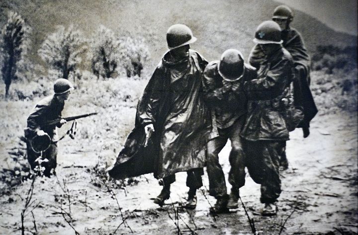 This is a copy photograph of Father Emil Kapaun, left, helping a wounded soldier that sits on display at Kapaun Mt. Carmel High School. The Kansas native served as a chaplain in World War II and the Korean war, where died a prisoner of war in 1951. The Catholic Diocese of Wichita is petitioning the Vatican to have Kapaun declared a Saint. (Photo by Mike Hutmacher/Wichita Eagle/MCT via Getty Images)