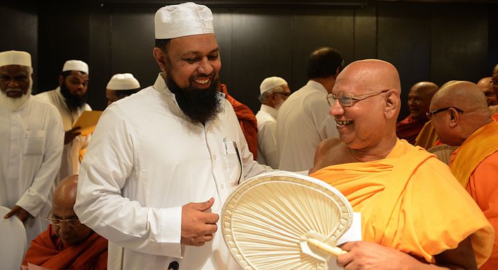 Sri Lankan All Ceylon Jamiyyathul Ulama (ACJU) Mufti, M.I.M. Rizwe (L) chats to the Ven Prof Bellanwila Wimalaratana Thera during a joint press conference by Buddhist monks and Islamic clerics in Colombo on March 11, 2013. Islamic clerics announced the withdrawal of a halal labelling system for food in Sri Lanka on Monday 'in the interests of peace' after protests from Buddhist hardliners on the Indian Ocean island. AFP PHOTO/Ishara S. KODIKARA (Photo credit should read Ishara S.KODIKARA/AFP/Getty Images)