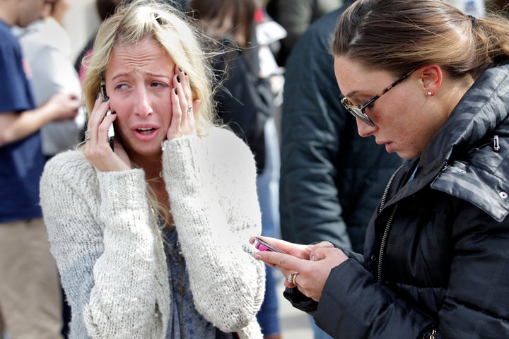 BOSTON - APRIL 15: Women desperate to hear from loved ones can't enter the scene at Boylston and Mass. Ave. after two explosions went off near the finish line of the 117th Boston Marathon on April 15, 2013. (Photo by Bill Greene/The Boston Globe via Getty Images)