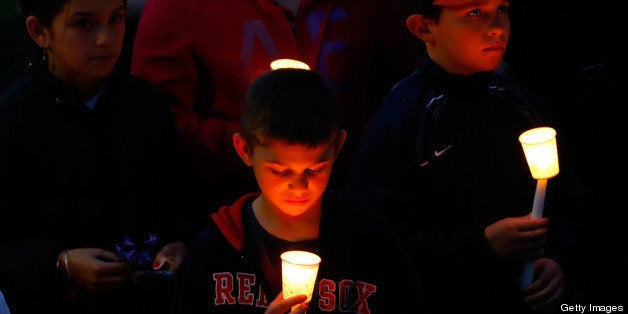 BOSTON, MA - APRIL 16: Young children stand with lit candles during a vigil for eight-year-old Martin Richard, from Dorchester, who was killed by an explosion near the finish line of the Boston Marathon on April 16, 2013 at Garvey Park in Boston, Massachusetts. The twin bombings resulted in the deaths of three people and hospitalized at least 128. The bombings at the 116-year-old Boston race resulted in heightened security across the nation with cancellations of many professional sporting events as authorities search for a motive to the violence. (Photo by Jared Wickerham/Getty Images)