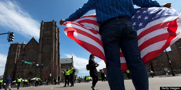 BOSTON - APRIL 18: Jose Briceno, of Cambridge, held a U.S. flag in front of the cathedral after the service was let out. 'There is no place for evil and hate in the community,' said Briceno. U.S. President Barack Obama, state and national politicians, and community members attended a service called 'Healing Our City: An Interfaith Service,' at the Cathedral of the Holy Cross for the victims of the Boston Marathon bombings in Boston, Mass. on Thursday, April 18, 2013. (Photo by Yoon S. Byun/The Boston Globe via Getty Images)