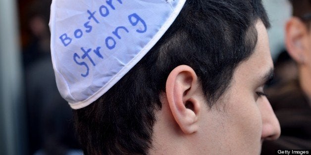 A man with a message written on his yarmulke stands across the street from the Cathedral of the Holy Cross where US President Barrack Obama and his wife Michelle attend an interfaith prayer service to honor the victims of the Boston Marathon bombings April 18, 2013 in the South End neighborhood of Boston, Massachusetts. AFP PHOTO/Stan HONDA (Photo credit should read STAN HONDA/AFP/Getty Images)