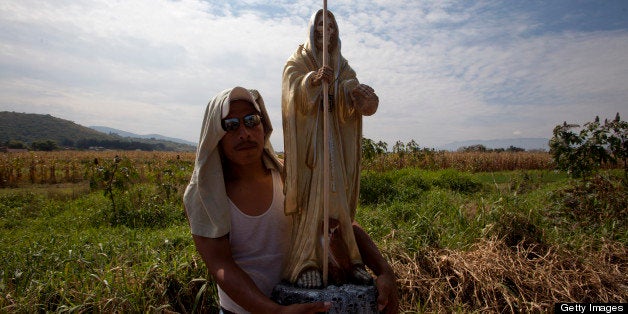 OAXACA, MEXICO - NOVEMBER 2: A man carries a skeletal figure representing the folk saint known in Mexico as 'Santa Muerte' or ' Death Saint' during a procession in Oaxaca, Mexico on November 2, 2012 . ( Photo by Claudio Cruz/LatinContent/Getty Images)