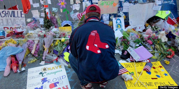 BOSTON - APRIL 22: Kevin Krueger of the North End pays his respect to the memorial on the Massachusetts Avenue end of Boylston Street. Two bombs went off at the finish line of the 117th Boston Marathon on Monday, and a memorial for the victims has since grown on the street.(Photo by Bill Greene/The Boston Globe via Getty Images)