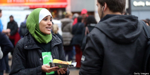 A member (L) of the Collective against Islamophobia in France (CCIF) distributes French pastries, called 'pain au chocolat,' in front of the Saint-Lazare railway station on October 10, 2012 in Paris to protest against the October 5 remarks made by the general secretary of the rightist French Union for a Popular Movement (UMP) party, Jean-Francois Cope, to UMP supporters in Draguignan about a boy who allegedly had his 'pain au chocolat' stolen by 'thugs' during the fasting month of Ramadan. AFP PHOTO / THOMAS SAMSON (Photo credit should read THOMAS SAMSON/AFP/GettyImages)