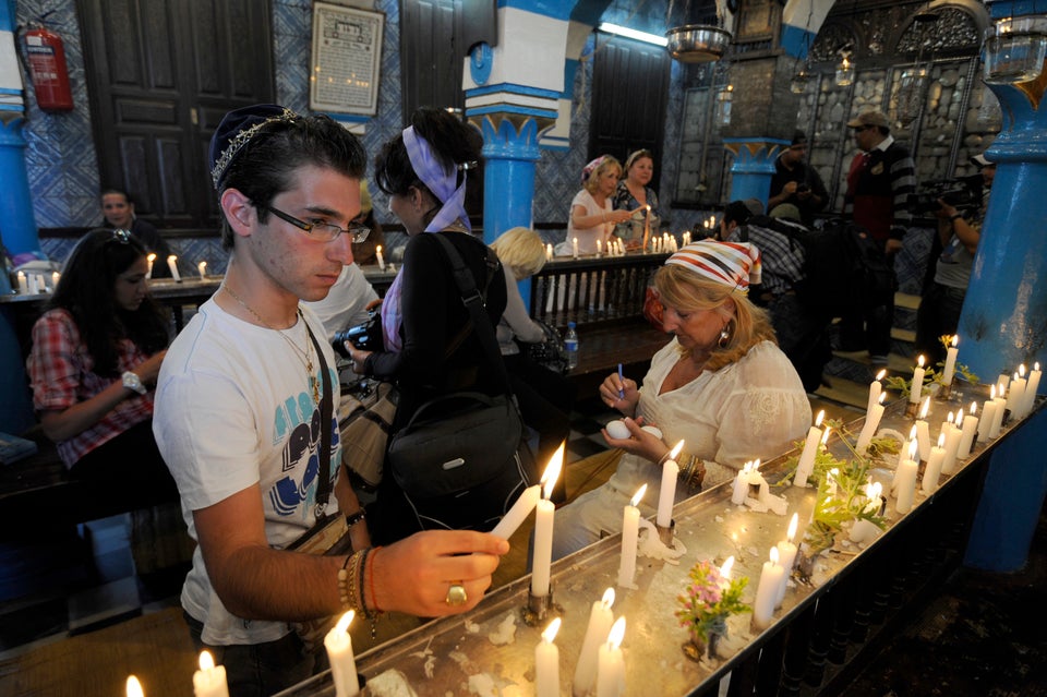 A Tunisian Jewish man lights a candle