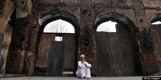 A Kashmiri Muslim man looks at the ruins of a revered 200-year old sufi shrine in downtown Srinagar on July 5,2012, which was gutted in a devasted fire recently.Thousands of devotees throng the place of worship daily and the number is expected to go-up tonight on the occassion of Shabi-e-barat, an auspicious night during which muslims offer special prayers seeking forgiveness from God.The shrine stood in Srinagar's khanyar locality in memory and respect of the 11th century sunni priest from persia Syed Abdul Qadir Geelani burried in Baghdad. AFP PHOTO/Tauseef MUSTAFA (Photo credit should read TAUSEEF MUSTAFA/AFP/GettyImages)