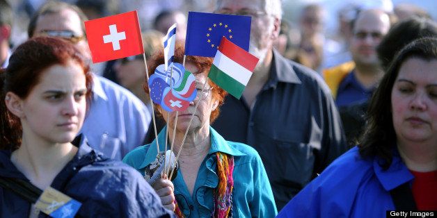 A woman holds flags of Hungary, Switzerland, Israel and the European Union as she takes part in a march of members of the Hungarian Jewish community and sympathizers along the banks of the Danube River in Budapest on April 21, 2013 during an Holocaust memorial ceremony. The event marks the 69th anniversary of the beginning of the Hungarian Holocaust during which 600,000 Hungarian Jews were deported to Nazi death camps in Austria, Germany and Poland. AFP PHOTO / ATTILA KISBENEDEK (Photo credit should read ATTILA KISBENEDEK/AFP/Getty Images)