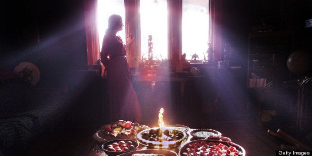 WICCAN COOKING01-03/18/01-Tmarra James is silhouetted by the afternoon light. In the foreground are examples of Wiccan cooking for the vernal equinox. Clockwise from near right is: beat pickled eggs; roast beef in tarragon; bowl of eggs boiled with onion skin wrap; bread with eggs; Ukranian painted eggs (centre); and apple crumble. For story on the ritualistic elements that can enhance the experience of food preparation. (BERNARD WEIL/TORONTO STAR) DIGITAL IMAGE (Photo by Bernard Weil/Toronto Star via Getty Images)