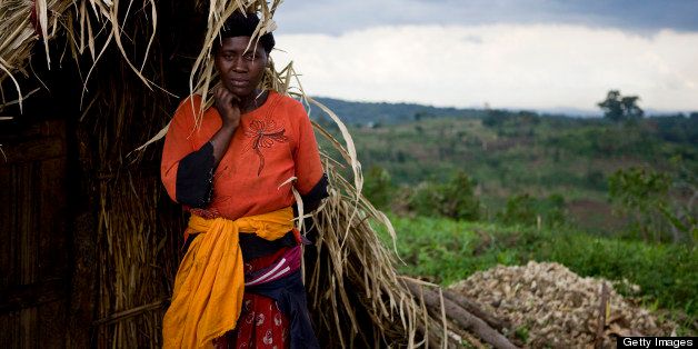 Portrait of Janet Kamigisha, 34, Kicucula village, standing in doorway of her straw house.