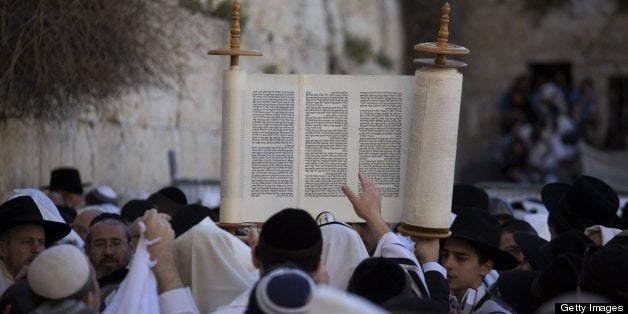 A Jewish man raises Torah scrolls during the Cohanim prayer (priest's blessing) during the Pesach (Passover) holiday at the W