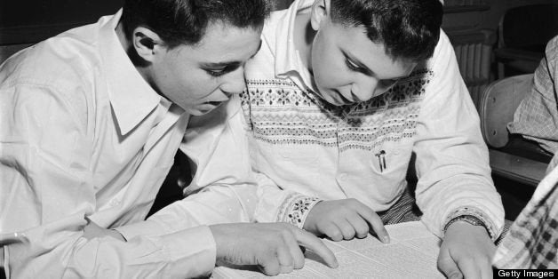 circa 1950: Jewish students celebrating the spring festival of Purim (Lots) by reading the Megillah in the synagogue. (Photo by Al Barry/Three Lions/Getty Images)