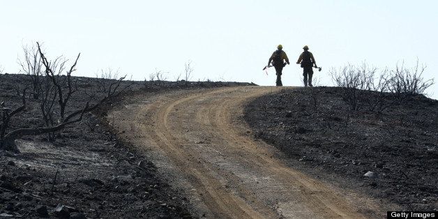 CAMARILLO, CA - MAY 4: U.S. Forest Service firefighters walk a scorched ridge at the Springs fire on May 4, 2013 near Camarillo, California. Improving weather conditions are helping firefighters get the upper hand on the wildfire which has grown to 28,000 acres and is now 56 percent contained. (Photo by David McNew/Getty Images)