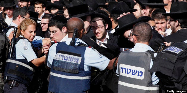 Israeli policemen push back a crowd of Ultra Orthodox Jewish men during the monthly prayer of the liberal Jewish religious group Women of the Wall on May 10, 2013 at the Western Wall in Jerusalem's Old City. Jerusalem police were holding five ultra-Orthodox Jewish men who had tried to disrupt landmark prayers by female Jewish activists at the Western Wall plaza in the Holy City. AFP PHOTO/GALI TIBBON (Photo credit should read GALI TIBBON/AFP/Getty Images)