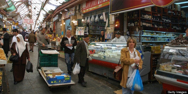 TO GO WITH AFP STORY BY RON BOUSSO Israelis, Palestinians and foreigners shop in Jerusalem's landmark Mahne Yehuda market on November 19, 2009. Signs of the changing times can be seen throughout the maze of narrow streets that make up Mahne Yehuda, which is known to locals simply as the 'Shuk' -- Hebrew for market. AFP PHOTO/MARINA PASSOS (Photo credit should read MARINA PASSOS/AFP/Getty Images)