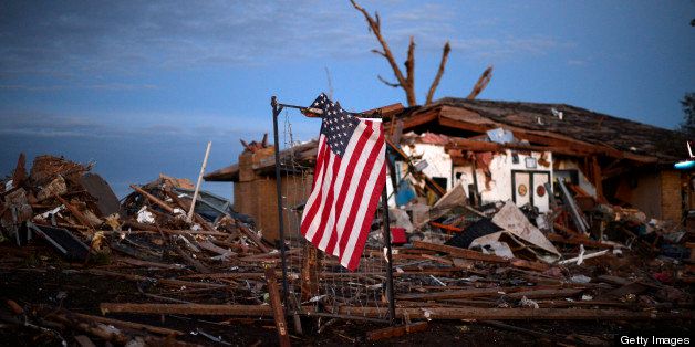 A US flag is seen amongst the debris of a torando devastated house on May 21, 2013 in Moore, Oklahoma. Families returned to a blasted moonscape that had been an American suburb Tuesday after a monstrous tornado tore through the outskirts of Oklahoma City, killing at least 24 people. Nine children were among the dead and entire neighborhoods vanished, with often the foundations being the only thing left of what used to be houses and cars tossed like toys and heaped in big piles. AFP PHOTO/Jewel Samad (Photo credit should read JEWEL SAMAD/AFP/Getty Images)