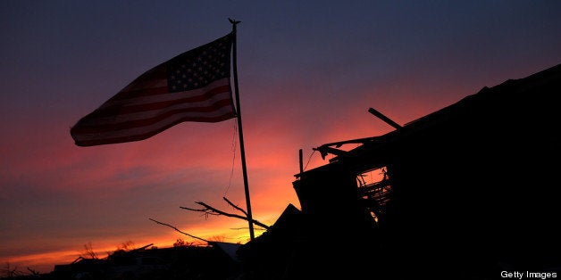 MOORE, OK - MAY 23: An American flag flies over a destroyed neighborhood on May 23, 2013 in Moore, Oklahoma. The tornado of at least EF4 strength and two miles wide touched down May 20 killing at least 24 people and leaving behind extensive damage to homes and businesses. U.S. President Barack Obama promised federal aid to supplement state and local recovery efforts. (Photo by Tom Pennington/Getty Images)