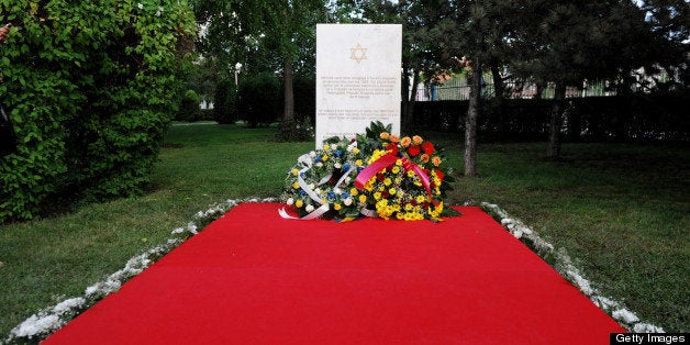 Flowers are placed in front of a plaque in Pristina on May 23, 2013, during an official ceremony of the Commemorative Plaque remembering Kosovo Jews that Perished in Holocaust, at the site where the last Synagogue of Kosovo stood until 1963. AFP PHOTO / ARMEND NIMANI (Photo credit should read ARMEND NIMANI/AFP/Getty Images)