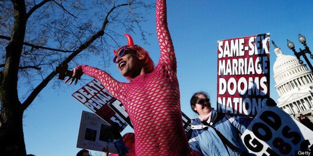 WASHINGTON, DC - MARCH 26: New York based drag performer Qween Amor dances during a rally while surrounded by protesters from the conservative Westboro Baptist Church in front of the U.S. Supreme Court on March 26, 2013 in Washington, DC. The Supreme Court is hearing arguments March 26, in California's proposition 8, the controversial ballot initiative that defines marriage only between a man and a woman. (Photo by Win McNamee/Getty Images)