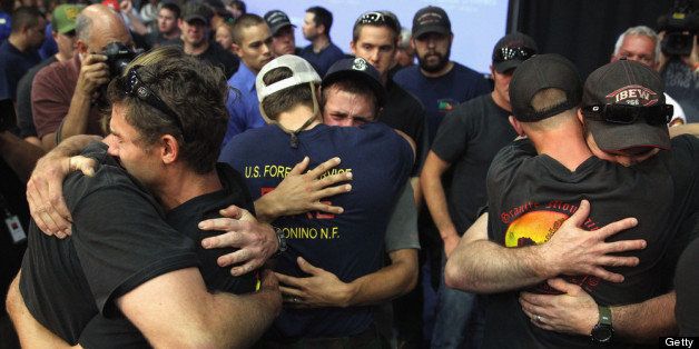 PRESCOTT, AZ - JULY 01: Local firefighters come together and embrace after being honored at a memorial service at EmbryRiddle Aeronautical University on July 1, 2013 in Prescott, Arizona. On Sunday 19 Granite Mountain Interagency Hotshot Crew firefighters died battling a fast-moving wildfire near Yarnell, AZ. (Photo by Christian Petersen/Getty Images)