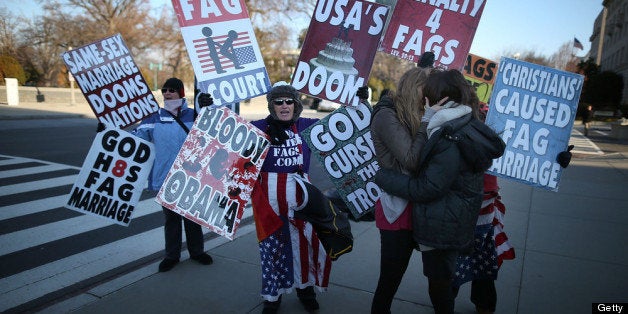 WASHINGTON, DC - MARCH 27: A same sex couple kisses in front of Westboro Baptist Church protesters, at the U.S. Supreme Court, on March 27, 2013 in Washington, DC. Today the high court is scheduled to hear arguments on whether Congress can withhold federal benefits from legally wed gay couples by defining marriage as only between a man and a woman. (Photo by Mark Wilson/Getty Images)