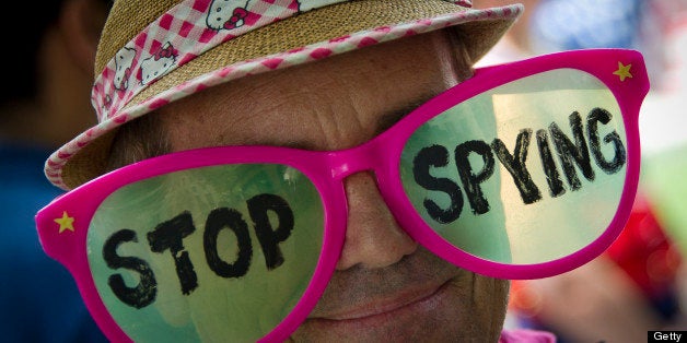 A human rights activists wears pink glasses reading 'stop spying' during a protest against the alleged violation of privacy b