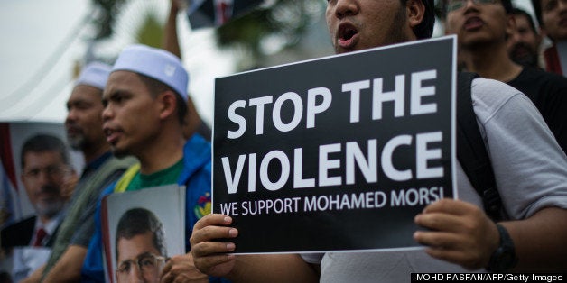 A Malaysian Islamist protester holds a placard during a protest to oppose the military overthrow of the Islamist leader and subsequent killings in Egypt, outside the Egyptian embassy in Kuala Lumpur on July 9, 2013. Fifty-one people, mostly Mohamed Morsi loyalists, were killed in Egypt on July 8 while rallying in favour of the ousted president, as the new rulers announced fresh elections by early 2014 amid US calls for restraint. AFP PHOTO / MOHD RASFAN (Photo credit should read MOHD RASFAN/AFP/Getty Images)