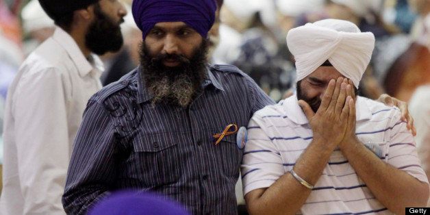 OAK CREEK, WI - AUGUST 10: A man grieves as community members pay respects to the six victims in the mass shooting at the Sikh Temple of Wisconsin at the Oak Creek High School August 10, 2012 Oak Creek Wisconsin. Suspected gunman, 40-year-old Wade Michael Page, allegedly killed six people at the temple on August 5 and then killed himself at the scene. He was an army veteran and reportedly a former member of a white supremacist heavy metal band. Three others were critically wounded in the attack. (Photo by Darren Hauck/Getty Images)