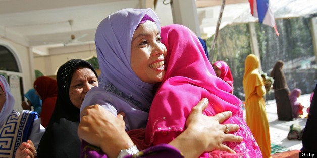 Thai Muslim women embrace after offering prayers at a mosque in Thailand's southern province of Narathiwat on August 19, 2012, as they celebrate Eid al-Fitr. Muslims around the world are celebrating this week Eid al-Fitr, marking the end of Ramadan, the Muslim calendar's ninth and holiest month during which followers are required to abstain from food, drink and sex from dawn to dusk. AFP PHOTO / Tuwaedaniya MERINGING (Photo credit should read Tuwaedaniya MERINGING/AFP/GettyImages)