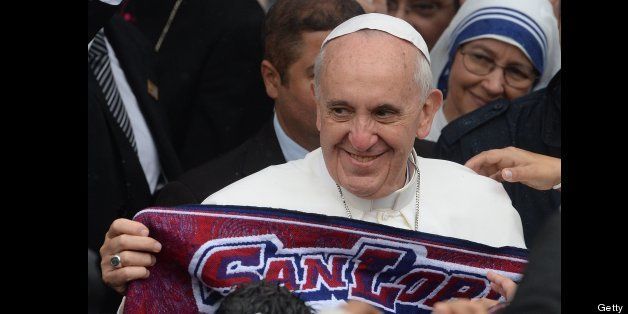 Pope Francis holds a scarf of Argentine football team San Lorenzo of which he is a fan, during his visit to the Sao Jeromino Emiliani church at the Varginha favela in Rio de Janeiro, on July 25, 2013. The Varginha favela is a community of 1,000 people which for decades was under the sway of narco-traffickers until it came under police control less than a year ago. The first Latin American and Jesuit pontiff arrived in Brazil mainly for the huge five-day Catholic gathering World Youth Day. AFP PHOTO / YASUYOSHI CHIBA (Photo credit should read YASUYOSHI CHIBA/AFP/Getty Images)