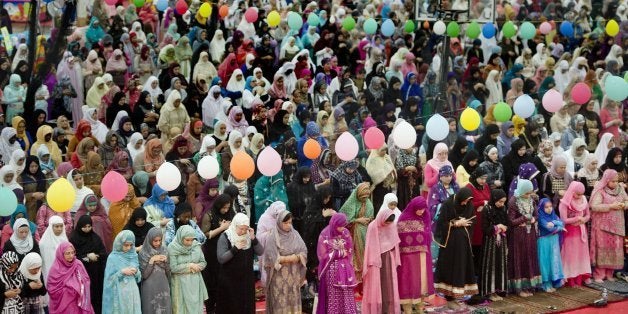 Women gather behind the men during the Eid prayer, marking the end of Ramadan, the Muslim month-long fasting ritual as more t