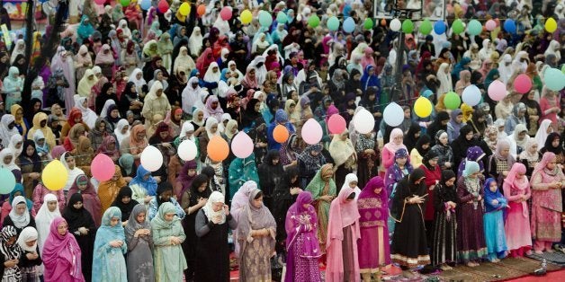 Women gather behind the men during the Eid prayer, marking the end of Ramadan, the Muslim month-long fasting ritual as more than 3,500 gathered inside the Jackson Sports Academy at McClellan Park on Thursday, August 8, 2013, in Sacramento, California. Eid celebrates the conclusion of the dawn-to-sunset fasting during the month of Ramadan. (Randy Pench/Sacramento Bee/MCT via Getty Images)