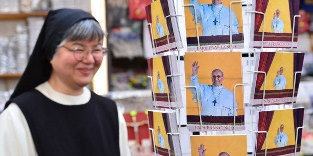 A nun looks at postcards of Pope Francis in a gift shop on March 15, 2013 near St Peter's square at the Vatican. Pope Francis was to address cardinals from around the world today following his stark warning that the Church risked becoming just another charitable organisation if it strayed from its true mission. AFP PHOTO / GIUSEPPE CACACE (Photo credit should read GIUSEPPE CACACE,GIUSEPPE CACACE/AFP/Getty Images)