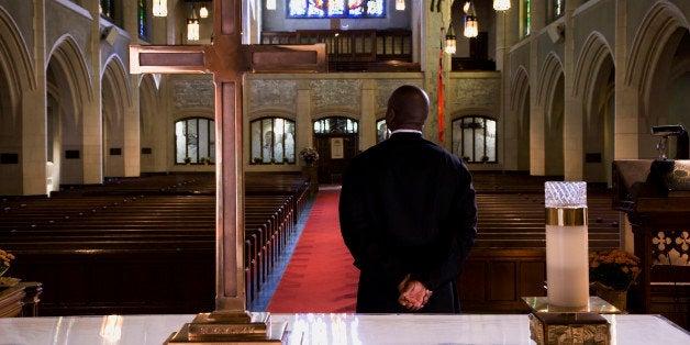 Mixed race pastor standing in front of church altar