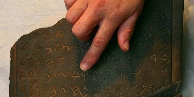 JERUSALEM - MARCH 27: An Israeli archaeologist reviews the inscription on the Jehoash tablet in the storerooms of the Israeli Antiquities Authority (IAA) March 27, 2003 in Jerusalem. The controversial basalt stone tablet is inscribed with an ancient Hebrew inscription attributed to the biblical Jewish King Jehoash who ruled Jerusalem in the ninth century BC. The tablet has been taken from the custody of an antiquities collector as IAA experts try to determine if it is a forgery. (Photo by David Silverman/Getty Images) 